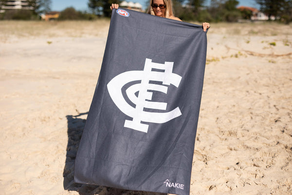 Carlton Blues navy beach towel with white logo and AFL badge, sand-free design displayed on beach