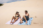 Image of a couple cozying up on a sandy beach while lying on Nakie's couple combo recycled sand-free beach towel, enjoying a romantic and sustainable beach experience together. preview #8