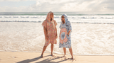 Woman in pink hooded towel on a beach Nakie - Australia