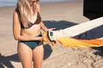 Kiteboarding glove with white and orange neoprene cuff, worn while holding kite on beach preview #7
