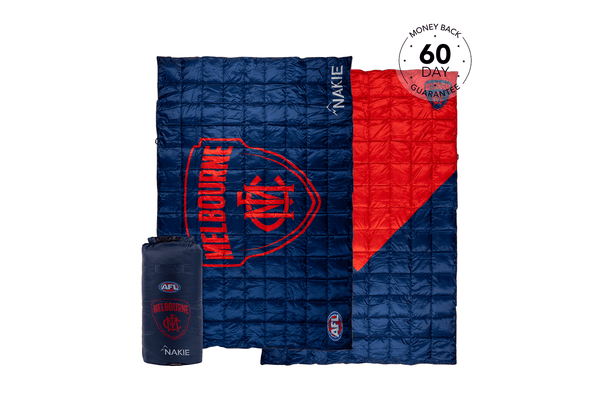 Melbourne Demons navy and red quilted puffy blanket with team logo, shown unfolded with matching compression bag.