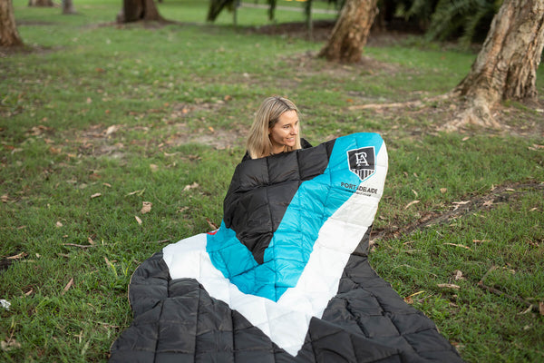 Port Adelaide Power AFL puffy blanket in turquoise, white and black, displayed outdoors on grass