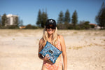 Blue and grey recycled sand-free beach towel with abstract wave pattern, held on beach by woman wearing cap and sunglasses preview #6