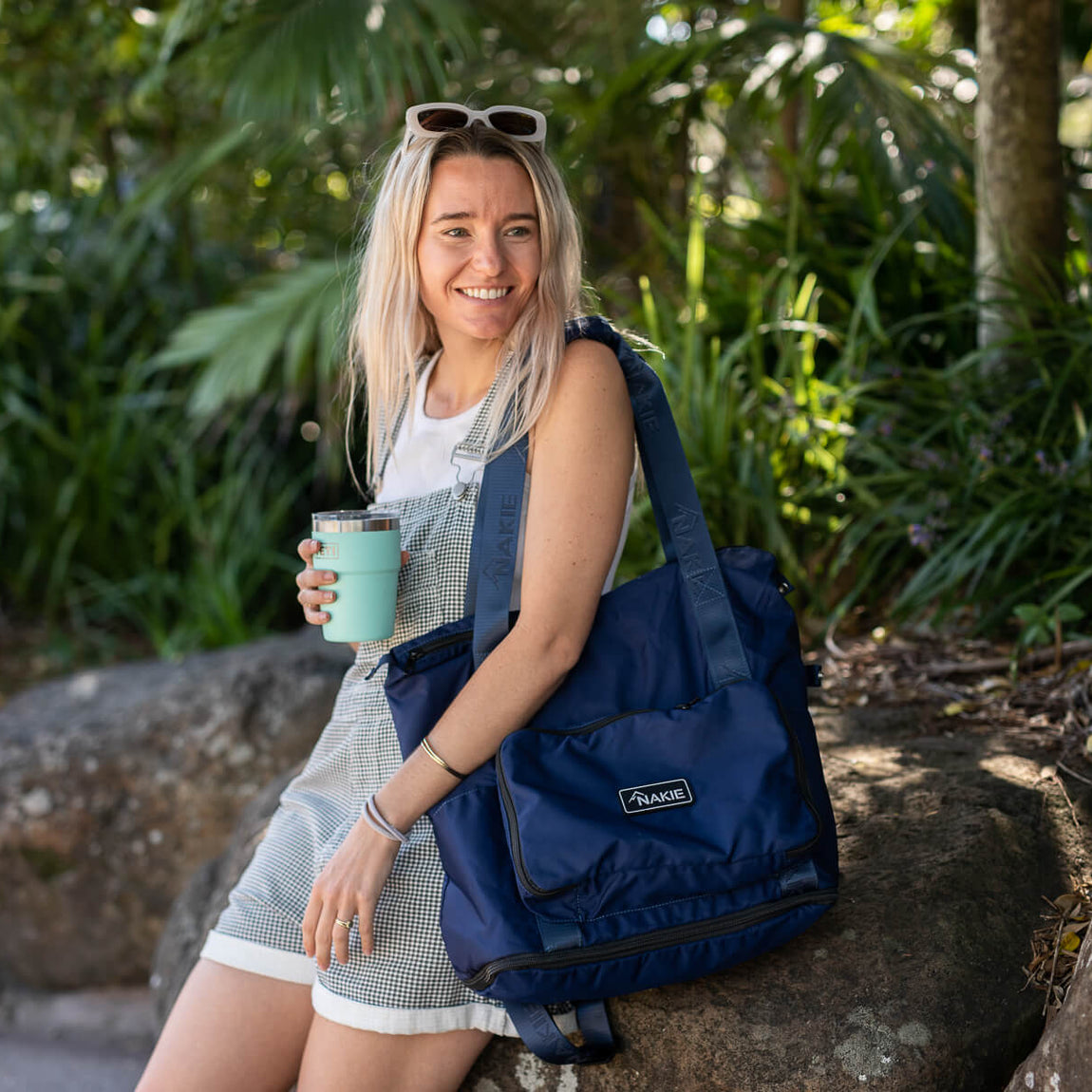 Navy recycled tote bag with handles, worn as shoulder bag by woman in garden setting