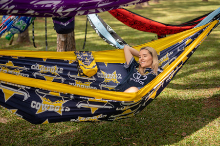 Person lounging in a Nakie NRL Cowboys hammock with friends