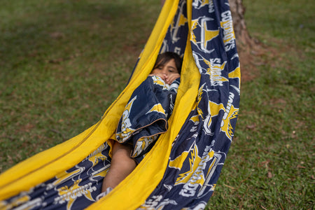 Child lying in a Nakie NRL Cowboys Navy and yellow hammock