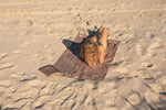 Brown recycled beach towel with embroidered detail, laid on sand with person resting on it preview #14