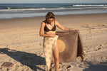 Recycled sand-free beach towel in taupe with sun and leaf print design, displayed on beach preview #9