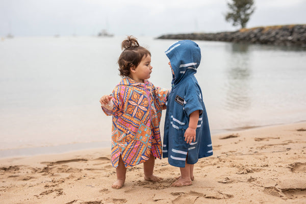 Blue striped kids hooded towel with white stripes worn at beach by toddler