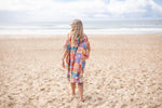 Colorful retro geometric hooded towel worn on beach, back view, showing vibrant multi-colored patchwork pattern. preview #10