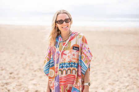 Colorful hooded towel with retro geometric and sea-life print in multicolor, worn on beach by model