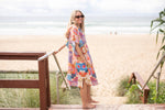 Hooded towel in bright multi-color retro print, worn as a beach cover-up at the shore. preview #6