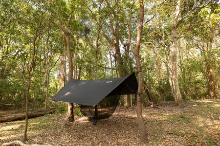 Nakie Bug Net & Rain Tarp Combo fully set up at a campsite, providing complete protection from insects and rain for a cozy outdoor experience.