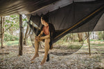 A man sitting comfortably in a Nakie hammock, protected by our Bug Net & Rain Tarp Combo, showcasing the ultimate outdoor relaxation experience with complete protection from insects and rain. preview #2