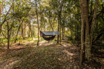A scenic view of Nakie's Bug Net & Rain Tarp Combo fully set up at a campsite, offering complete protection and comfort for outdoor enthusiasts. preview #5