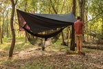 A man effortlessly setting up Nakie's Bug Net & Rain Tarp Combo, preparing for a comfortable and protected outdoor experience. preview #7